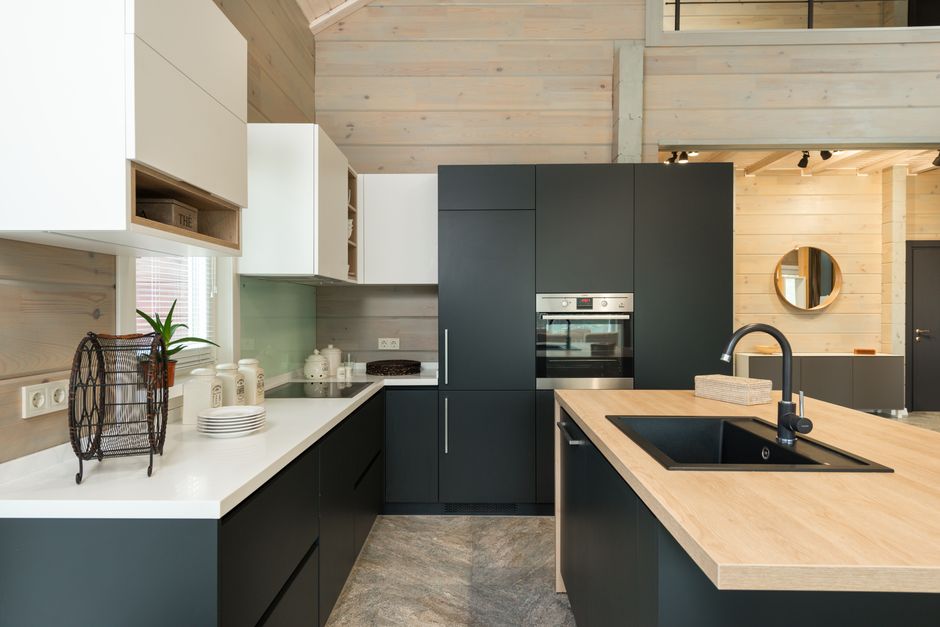 Kitchen with black and white cabinets, a built-in oven, a stove and a sink.
